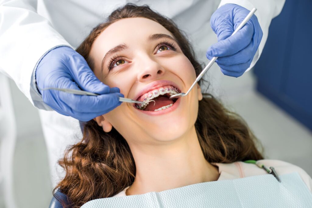 A woman having her braces checked by an orthodontist.